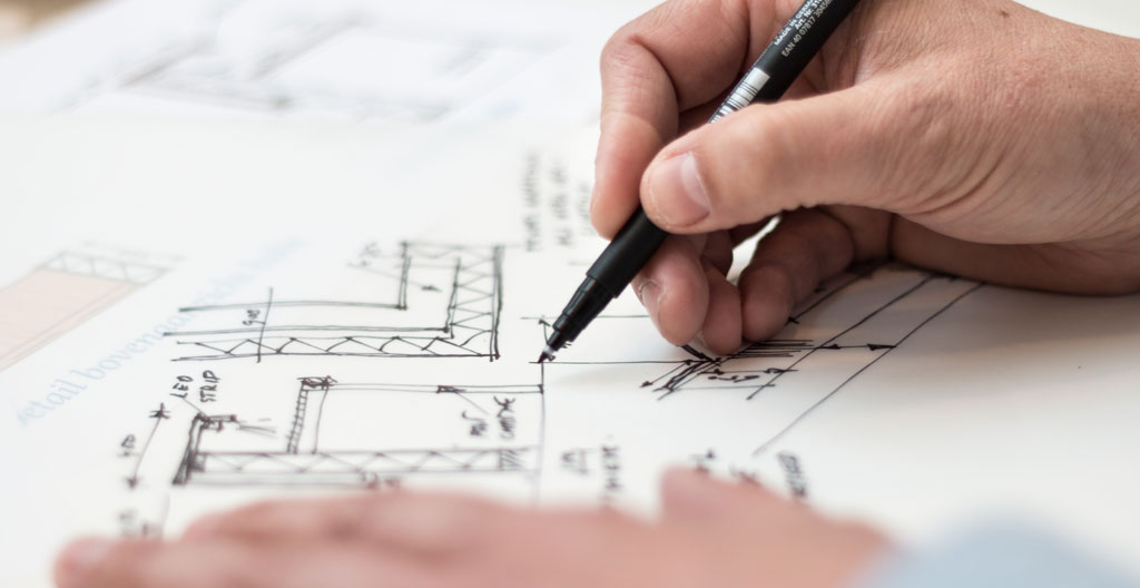 Responsable de chantier consultant un plan d'implantation sur tablette devant des séparateurs de voies
